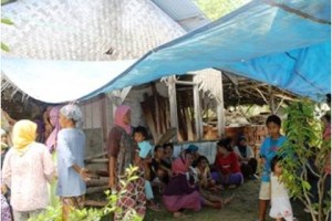 Tampak sejumlah warga transmigrasi lokal sedang bercengkrama di depan rumah yang sudah tidak layak huni.