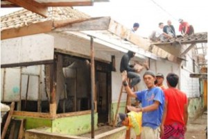 Warga gotong royong bangun rumah tidak layak huni.