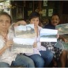 Erlan Effendy didampingi isterinya Toni Ellen berfoto bersama dengan Eka Santosa seraya menunjukan bukti ANDALnya.