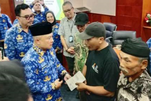 Bupati Kuningan saat menyalurkan BLT DBHCHT kepada wrga secara simbolik.
